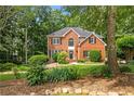 Traditional brick home with manicured lawn, mature trees, and well-maintained landscaping at 6435 Ivey Creek Cir, Cumming, GA 30040
