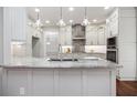 Gourmet kitchen island with granite countertop, stylish pendants, and ample cabinet space at 6435 Ivey Creek Cir, Cumming, GA 30040