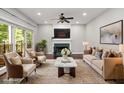 Bright living room featuring a fireplace, large windows, and neutral-toned furniture at 6435 Ivey Creek Cir, Cumming, GA 30040