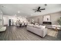Open-concept living room and kitchen featuring wood floors, modern lighting, and stainless steel appliances at 947 Edwin Ln, Sugar Hill, GA 30518