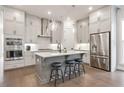 Well-lit kitchen with stainless steel appliances, light grey cabinets, and hardwood floors at 134 Everley Walk, Alpharetta, GA 30009