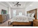 Spacious bedroom with tray ceilings, shiplap accent wall, and access to a balcony at 134 Everley Walk, Alpharetta, GA 30009