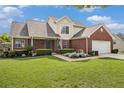 Beautiful two-story home with brick facade, lush lawn, and an American flag accenting the front garden at 1698 Bennett Dr, Mcdonough, GA 30253