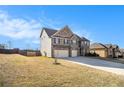 View of the home's side, showcasing the attached three-car garage and spacious yard at 3621 Guinevere Trce, Douglasville, GA 30135