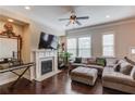 Bright and airy living room with a fireplace, large windows, and hardwood floors at 4405 Donahue Ave, Sugar Hill, GA 30518