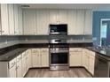 Bright kitchen featuring granite countertops, stainless steel appliances, and stylish cabinets with wood flooring at 4635 Tims Pl, Snellville, GA 30039
