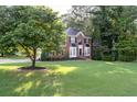 Beautiful brick home with manicured lawn, mature trees, and classic curb appeal at 1001 Braelin Ct, Woodstock, GA 30189