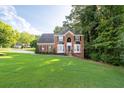 Attractive two-story brick home on a spacious lot with lush green lawn at 1001 Braelin Ct, Woodstock, GA 30189