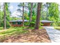 Inviting brick home boasts lush front lawn, mature trees, and a paved driveway at 3219 W Manor Ln, Atlanta, GA 30311