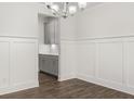 Dining room showcases wainscoting, hardwood floors, and a glimpse into the kitchen at 7160 Linden Dr, South Fulton, GA 30349