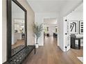 Inviting foyer with hardwood floors, decorative mirror, and views into the open-concept living spaces at 6106 Marigold Way, Atlanta, GA 30349