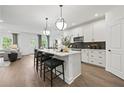 Modern eat-in kitchen with white cabinets, quartz countertops, stainless appliances and pendant lighting at 6106 Marigold Way, Atlanta, GA 30349