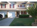 Well-maintained townhome with an attached garage, covered porch, and nicely landscaped yard at 70 Darbys Crossing Ct, Hiram, GA 30141