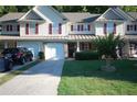 Inviting townhome featuring an attached garage, covered front porch, and lush green lawn at 70 Darbys Crossing Ct, Hiram, GA 30141