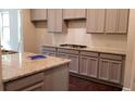 Bright kitchen boasting grey cabinets, granite counters, and tiled backsplash at 3272 Baylor Cir, Mcdonough, GA 30253