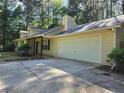 Wide driveway leading to a two-car garage enhances the curb appeal at 115 Bond Dr, Ellenwood, GA 30294