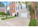 Townhome exteriors featuring brick and gray siding, with one car garages, blue shutters and landscaped lawns at 5357 Beaver Br, Norcross, GA 30071