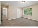 Bright bedroom with neutral walls, plush carpet, and a large window overlooking the backyard at 2120 Glenwood Downs Dr, Decatur, GA 30035