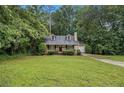 Inviting single-Gathering home with a green lawn, mature trees, and an attached garage at 2120 Glenwood Downs Dr, Decatur, GA 30035