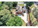 Expansive aerial view of a brick house, mature trees, and a private backyard with a deck at 5121 Hunters Hill Sw Cv, Lilburn, GA 30047