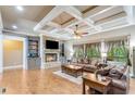 Inviting living room with coffered ceilings, hardwood floors, a stone fireplace, and built-in shelving at 8240 Hurakan Creek Xing, Cumming, GA 30028