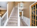Entryway featuring carpeted stairs, light-colored walls, and a view to the kitchen at 3740 Arminto Dr, Ellenwood, GA 30294