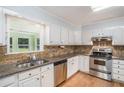 Well-lit kitchen with stainless steel appliances, granite countertops, and a view to the backyard at 95 Oak Grove Cir, Mcdonough, GA 30253