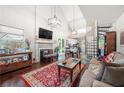 Bright living room with hardwood floors, a fireplace, large windows, and a view of the open staircase at 1901 Brittania Cir, Woodstock, GA 30188