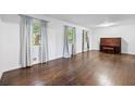 Living room with hardwood floors, piano, three windows and lots of natural light at 1971 Hooper St, Decatur, GA 30032