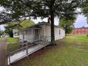 Home featuring an enclosed front porch and a ramp for accessible entry at 29 Ivy St, Porterdale, GA 30014
