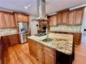 Spacious kitchen with stainless steel appliances, granite island with seating, and ample cabinet space at 4265 Lansmoore Xing, Suwanee, GA 30024