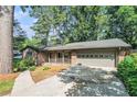 Beautiful home exterior featuring a well-kept lawn, mature trees, and a paved driveway at 1260 Fork Creek Trl, Decatur, GA 30033