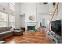 Cozy living room with hardwood floors, fireplace, large windows and staircase to second floor at 3616 Myrtlewood Nw Ct, Kennesaw, GA 30144
