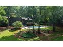 Expansive, secluded backyard with a stunning pool, multilevel deck, and surrounded by mature trees and manicured landscaping at 1510 Chevron Dr, Sandy Springs, GA 30350