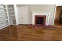 Living room showcasing a decorative fireplace, built-in shelving and hardwood floors at 2807 Mcclave Dr, Doraville, GA 30340