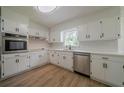 Well-lit kitchen featuring white cabinets, modern countertops, stainless steel appliances, and updated flooring at 4732 Manly Ct, Stone Mountain, GA 30088