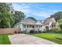 Inviting exterior of a bungalow featuring a cozy front porch, complemented by a spacious driveway and green lawn at 1292 Eubanks Ave, East Point, GA 30344