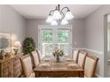 Dining area featuring a rustic wooden table, chandelier, and French doors leading to a deck, perfect for gatherings at 1404 Lancaster Ct, Mcdonough, GA 30252