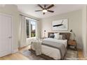 Staged bedroom featuring a ceiling fan, a plush bed, neutral walls, and a large window with a cityscape view at 285 Centennial Olympic Park Nw Dr # 809, Atlanta, GA 30313