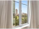 A bright window frames a view of the city skyline and green space, creating a pleasant, airy atmosphere at 285 Centennial Olympic Park Nw Dr # 809, Atlanta, GA 30313