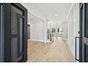 Bright foyer featuring light hardwood floors, staircase and a modern black door at 3061 Bold Springs Rd, Dacula, GA 30019