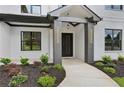 A close-up of the front door with a concrete walkway and landscaped garden at 3061 Bold Springs Rd, Dacula, GA 30019
