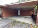 Spacious carport with a concrete floor and brick column supports offer sheltered parking at 1932 Pharrs Rd, Snellville, GA 30078