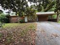 Modest one-story home featuring a brick facade, a large carport, and a driveway at 1932 Pharrs Rd, Snellville, GA 30078