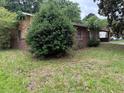 Modest one-story home featuring a brick facade, a large carport, and a grassy yard at 1932 Pharrs Rd, Snellville, GA 30078