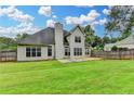 Spacious backyard featuring a large patio, fenced yard, and lush green grass at 5036 Weatherstone Drive, Buford, GA 30519