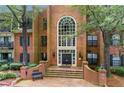 An elegant brick building exterior with a grand entrance, complemented by manicured landscaping and mature trees at 26303 Plantation Ne Dr # 303, Atlanta, GA 30324
