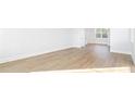 Bright living room with hardwood floors, white walls, and natural light from large windows at 5449 Baybrook Cir, South Fulton, GA 30349