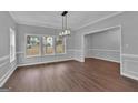 Elegant dining room with hardwood floors, wainscoting, and large windows for natural light at 250 Stonecreek Pkwy, Covington, GA 30016