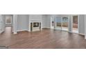 Spacious living room featuring wood floors, a fireplace, and a sliding glass door to the backyard at 250 Stonecreek Pkwy, Covington, GA 30016